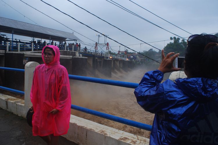 Warga asyik berfoto di lokasi Bendungan Katulampa, Bogor, Senin (5/2/2018). Sejak pagi, ketinggian muka air di bendungan ini sudah mencapai 220 sentimeter dan berstatus Siaga 1.