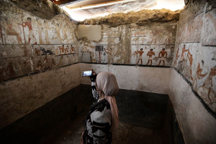 Seorang wanita mengambil foto di dalam makam Hetpet. / AFP PHOTO / MOHAMED EL-SHAHED