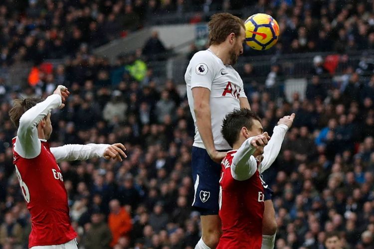 Penyerang Tottenham Hotspur, Harry Kane (putih), berusaha menyundul bola di tengah kawalan pemain Arsenal, Sabtu (10/2/2018).