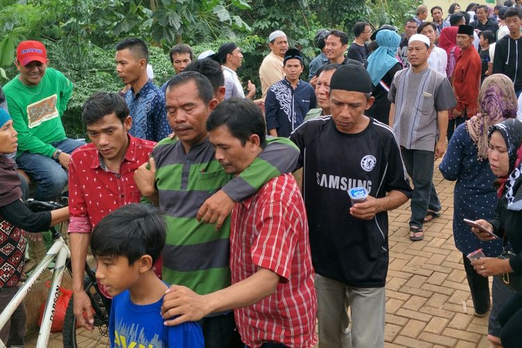 Salah satu kerabat korban kecelakaan maut Tanjakan Emen harus berjalan sambil dipapah usai pemakaman di Ciputat Timur, Tangerang Selatan, Minggu (11/2/2018)