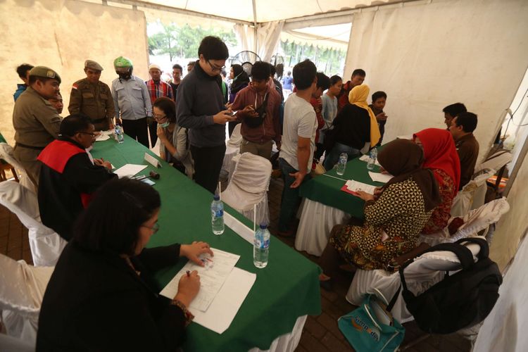 Petugas melakukan pendataan kepada warga yang tidak membawa kartu tanda penduduk (KTP) saat operasi yustisi di Kawasan Bumi Serpong Damai, Tangerang Selatan, Selasa (22/02/2018). Operasi yang dilakukan Dinas Kependudukan dan Catatan Sipil ini bertujuan agar tertib administrasi kependudukan kepada seluruh masyarakat yang ada di Indonesia.