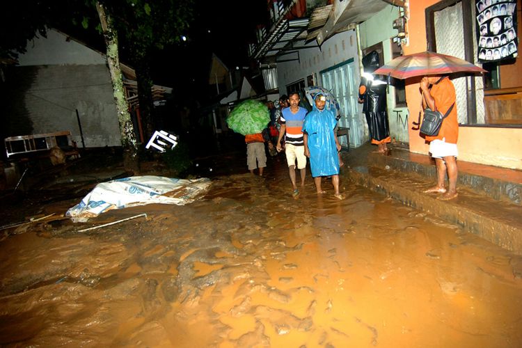 Sejumlah warga terdampak banjir bandang berjalan untuk mencari tempat mengungsi di Desa Pasirpanjang, Salem, Brebes, Jawa Tengah, Kamis (22/2/2018) malam. Puluhan warga terpaksa mengungsi akibat rumahnya terkena banjir bandang dampak tertutupnya Sungai Cipangurudan akibat longsor bukit Gunung Lio.