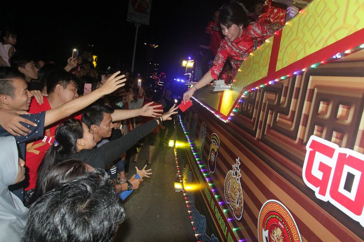 Wali Kota Singkawang, Tjhai Chui Mie saat membagikan angpau kepada masyarakat yang menyaksikan pawai lampion dalam perayaan Imlek dan Cap Go Meh di Singkawang, Kalimantan Barat (28/2/2018).