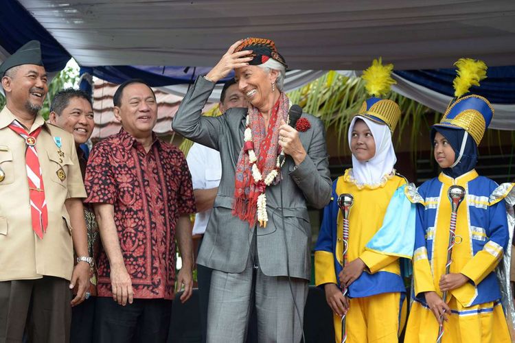 Managing Director International Monetary Fund (IMF) Christine Lagarde mencoba mengenakan blangkon dalam kunjungannya di Cilincing, Jakarta, Rabu (28/2/2018). Lagarde menyambangi Jakarta untuk menghadiri konferensi internasional tingkat tinggi sekaligus persiapan untuk pertemuan tahunan IMF dan Kelompok Bank Dunia yang akan diselenggarakan di Nusa Dua, Bali, Oktober mendatang.