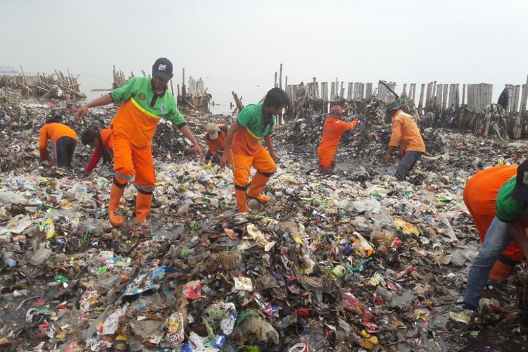 Petugas mulai membersihkan  lautan sampah di Muara Angke pada Sabtu (17/3/2018).