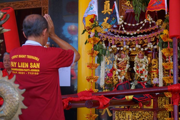 Seorang umat Tridharma sedang sembahyang di depan  altar di Klenteng Hoo Tong Bio Banyuwangi