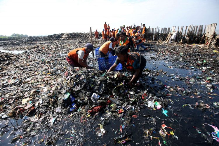 Petugas membersihkan lautan sampah yang menumpuk di kawasan Teluk Jakarta, Muara Angke, Jakarta Utara, Minggu (18/3/2018). Sejumlah 400 personel petugas gabungan dikerahkan membersihkan limbah domestik rumah tangga yang memenuhi perairan di Teluk seluas 7.500 meter persegi.