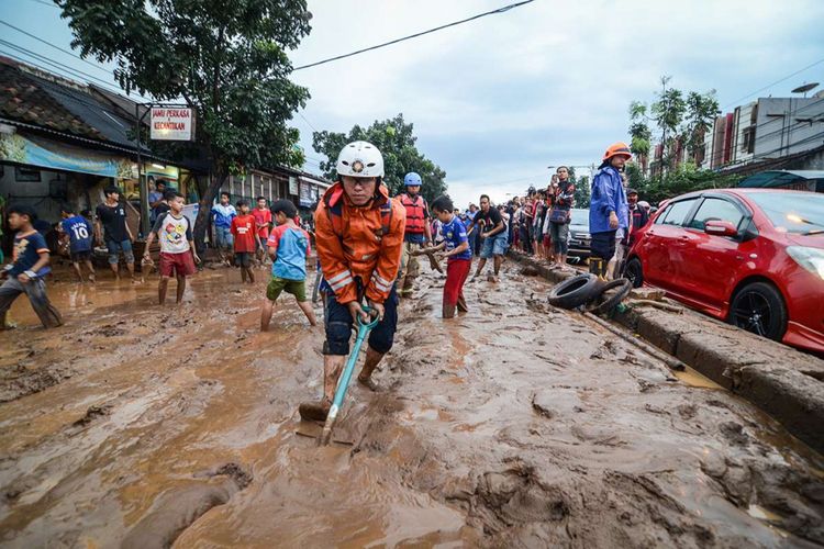 Petugas pemadam kebakaran Kota Bandung membersihkan lumpur akibat banjir bandang di Jalan AH Nasution, Bandung, Jawa Barat, Selasa (20/3/2018). Banjir bandang yang disertai lumpur tersebut disebabkan oleh luapan Sungai Cipamokolan akibat intensitas hujan yang tinggi di beberapa wilayah Kota Bandung.