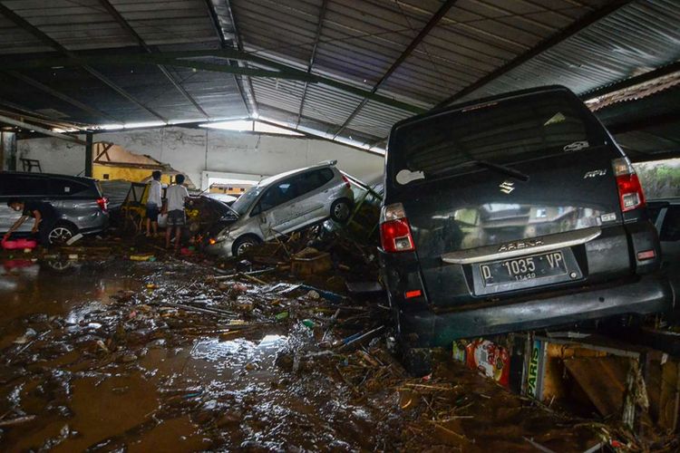 Warga mengamati kendaraan yang terseret banjir bandang di Cicaheum, Bandung, Jawa Barat, Selasa (20/3/2018). Banjir bandang yang disertai lumpur tersebut disebabkan oleh luapan Sungai Cipamokolan akibat intensitas hujan yang tinggi di beberapa wilayah Kota Bandung.