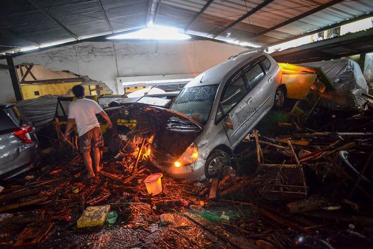 Warga mengamati kendaraan yang terseret banjir bandang di Cicaheum, Bandung, Jawa Barat, Selasa (20/3/2018). Banjir bandang yang disertai lumpur tersebut disebabkan oleh luapan Sungai Cipamokolan akibat intensitas hujan yang tinggi di beberapa wilayah Kota Bandung.