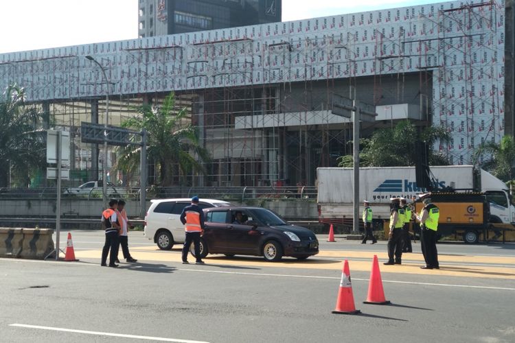 Mobil dengan plat nomor ganjil berputar arah setelah masuk ke gerbang tol Bekasi Barat, Senin (26/3/2018)