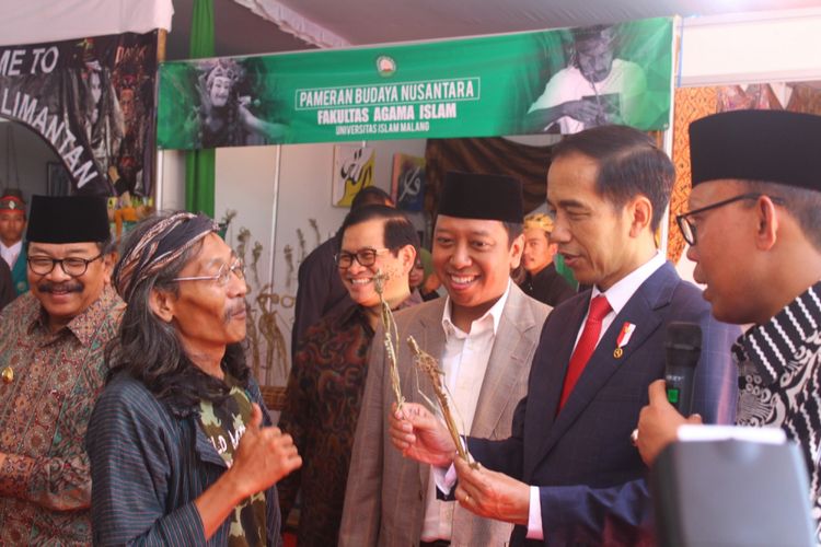 Presiden Joko Widodo menerima pemberian wayang suket saat menghadiri Stadium General dan Peresmian Gedung Bundar Al Assyari dan Gedung Pusat Umar Bin Khattab Universitas Islam Malang (Unisma), Kamis (29/3/2018).