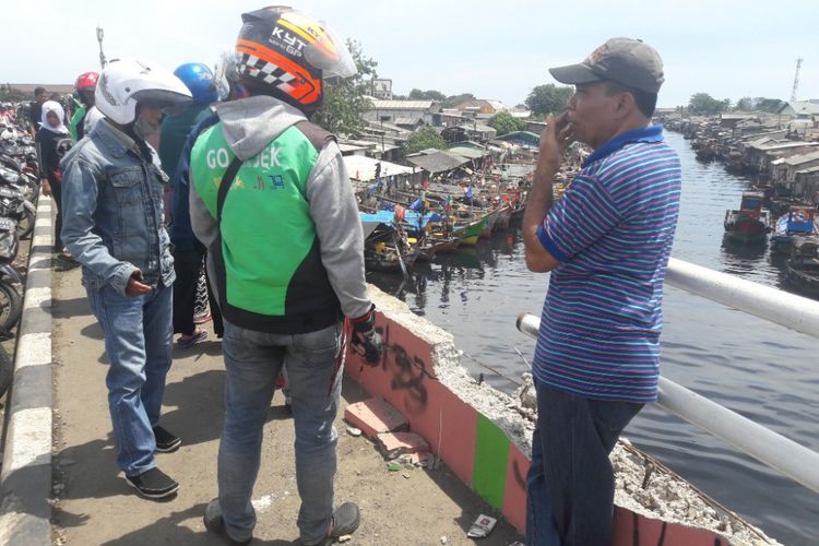 Lokasi kejadian jatuhnya angkot di jembatan Lestari, Cilincing, Jakarta Utara, dikerumuni warga yang penasaran pada Kamis (12/4/2018). 