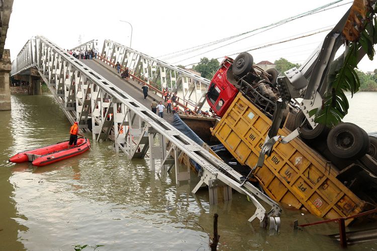 Petugas mengevakuasi truk di lokasi jembatan Widang yang runtuh, Tuban, Jawa Timur, Selasa (17/4/2018). Sisi barat jembatan itu runtuh sekitar 50 meter, mengakibatkan 2 orang meninggal dunia, 1 orang ditemukan selamat, dan 1 orang lainnya masih dalam pencarian, sementara tiga truk dan sebuah sepeda motor masuk ke Bengawan Solo.