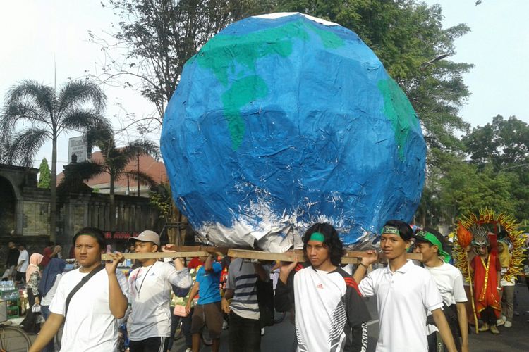 Mahasiswa FSRD UNS Solo mengarak keliling bola tiruan bumi (globe) keling Jalan Slamet Riyadi untuk memperingati Hari Bumi di Solo, Jawa Tengah, Minggu (22/4/2018).