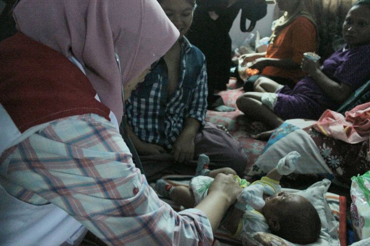Bidan Puskesmas Kalibening, Endang Sri Hastuti memeriksa bayi yang ada di Posko Pengungsian Khusus, Desa Kasinoman, Kecamatan Kalibening, Banjarnegara, Jawa Tengah, Sabtu (21/4/2018).