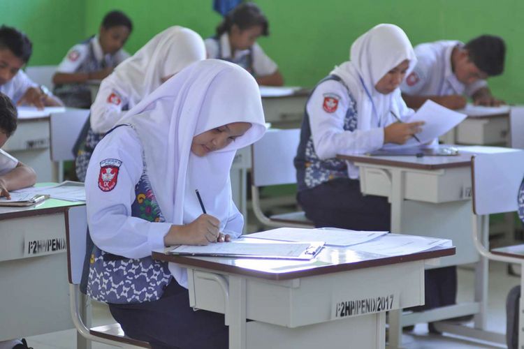 Sejumlah pelajar SMP Negeri 18 Palu mengerjakan soal ujian nasional dengan skema ujian nasional berbasis kertas dan pensil (UNKP) di SMP Negeri 18 Palu, Kelurahan Mamboro, Palu Utara, Sulawesi Tengah, Senin (23/4/2018). Sebagian sekolah SMP di Kota Palu belum dapat melaksanakan ujian nasional berbasis komputer (UNBK) karena keterbatasan fasilitas terutama komputer.