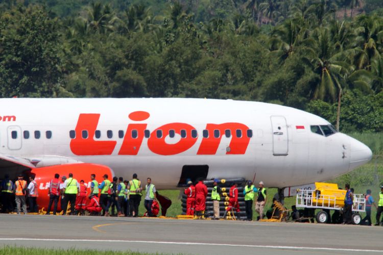 Sejumlah petugas berusaha memindahkan pesawat Lion Air yang tergelincir di Bandara Jalaluddin Tantu Gorontalo. Upaya mereka belum menemukan keberhasilan