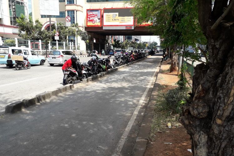 Sejumlah pengemudi ojek online tetap nekat memarkirkan kendaraannya di tepian jalur bus Transjakarta di Jalan Mangga Dua Raya, Jakarta Utara, tepatnya di depan ITC dan Mal Mangga Dua, Senin (7/5/2018).