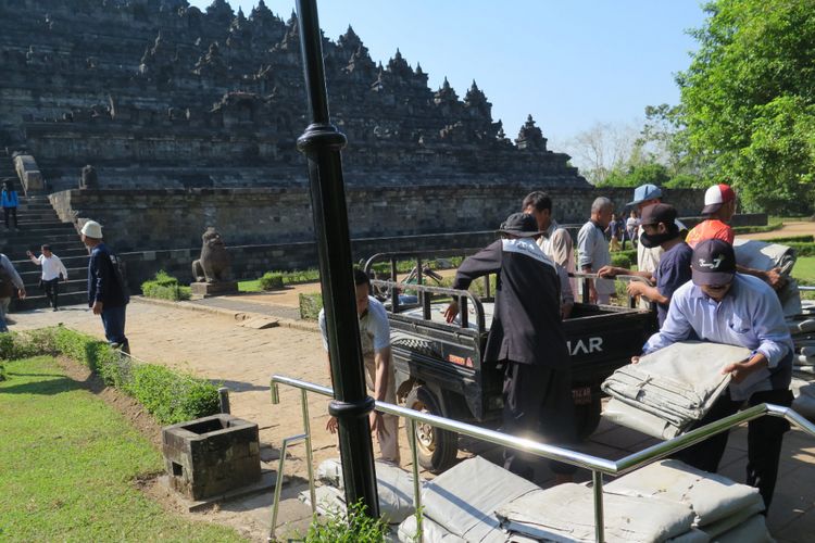 Petugas menyiapkan terpaulin penutup candi Borobudur di dekat candi untuk antisipasi dampak abu vulkanik pasca-erupsi freatik gunung Merapi, Magelang, Jawa Tengah, Jumat (11/5/2018).
