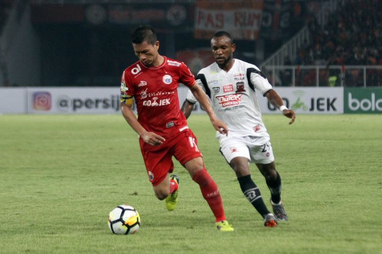 Pemain Persija Jakarta, Ismed Sofyan, sedang mempertahan bola dari pemain Madura United, Zah Rahan, Sabtu (12/5/2018)
