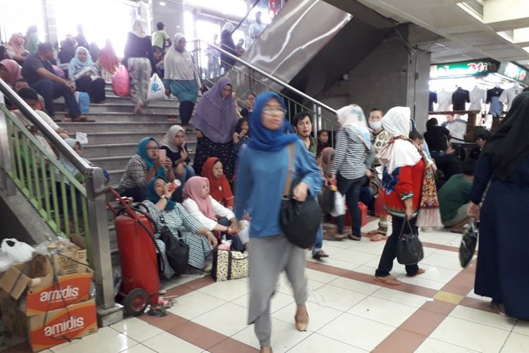 Pengunjung Pasar Tanah Abang terpaksa duduk di anak tangga akibat sedikitnya jumlah bangku di pusat grosir terbesar se-Asia Tenggara tersebut, Sabtu (12/5/2018).