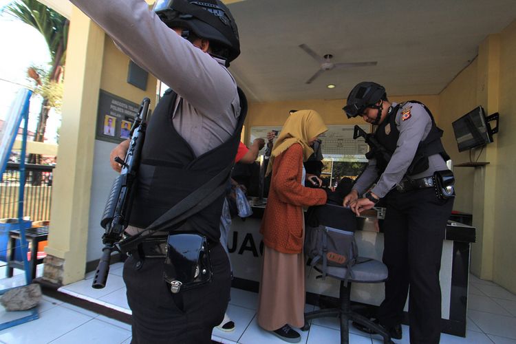 Petugas kepolisian memeriksa warga yang akan masuk ke Mapolres Indramayu, Jawa Barat, Senin (14/5/2018). Petugas memperketat penjagaan kawasan Markas Polres Indramayu pascaledakan bom di sejumlah titik di Surabaya.
