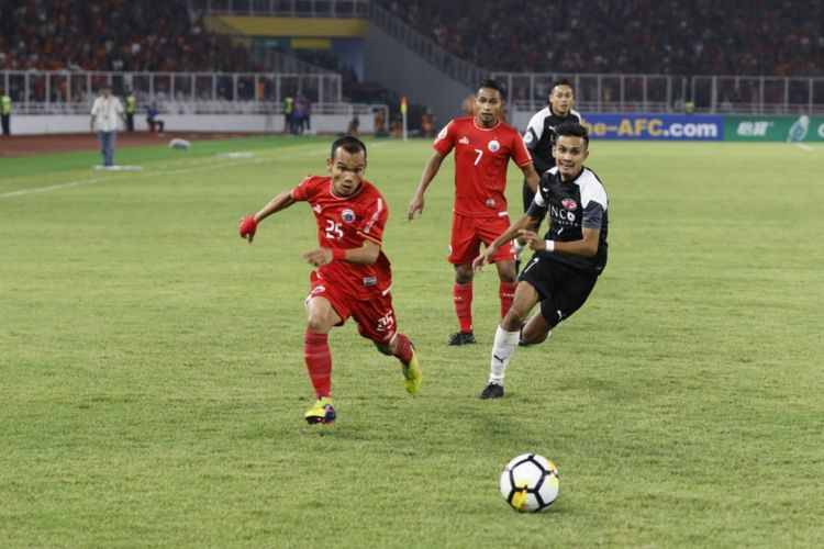 Pemain Persija, Riko Simanjuntak (kiri) dibayangi pemain Home United pada laga leg kedua semifinal Piala AFC 2018 di SUGBK, Selasa (15/5/2018).