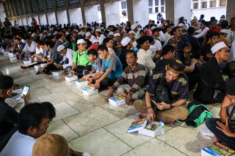 Warga berbuka puasa bersama di Masjid Istiqlal, Jakarta Pusat, Jumat (18/5/2018). Pengurus Masjid Istiqlal setiap hari menyiapkan 4.000 nasi bungkus dan takjil untuk berbuka puasa selama Ramadhan.