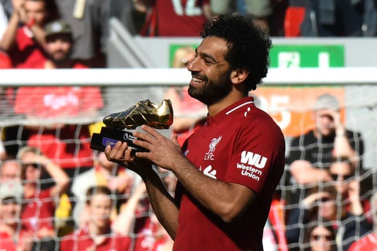 Mohamed Salah memamerkan sepatu emas sebagai simbol pencetak gol terbanyak Premier League seusai laga Liverpool vs Brighton & Hove Albion di Anfield,13 Mei 2018.