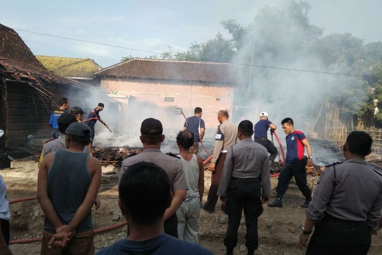 PADAMKAN --Aparat polisi, TNI dan warga bahu membahu memadamkan api yang membakar rumah Gumbrek. 