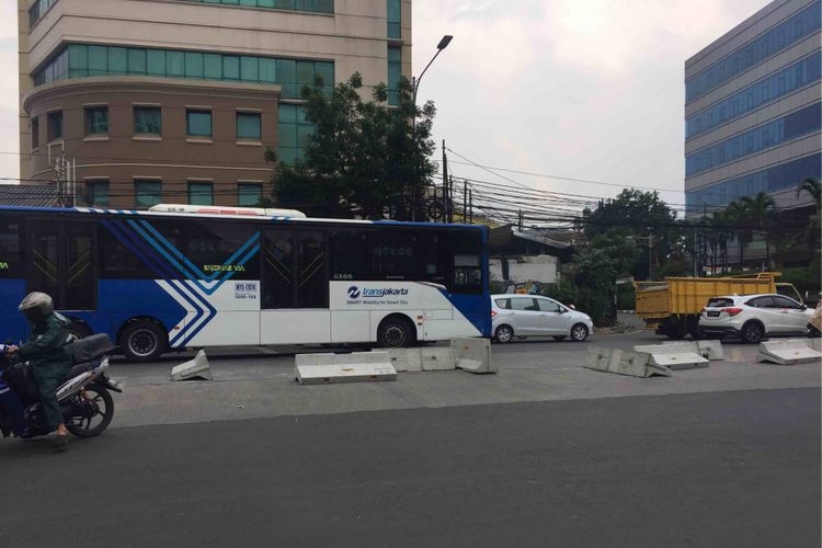 Puluhan warga dibantu pengendara yang melintas membongkar pembatas jalan di Simpang Duren Tiga, Kelurahan Duren Tiga, Kecamatan Pancoran, Jakarta Selatan, Sabtu (19/5/2018). Adapun pembatas jalan tersebut dipasang sebagai bagian uji coba penutupan simpang untuk memperlancar arus lalu lintas pasca-beroperasinya lintas bawah atau underpassMampang-Kuningan.