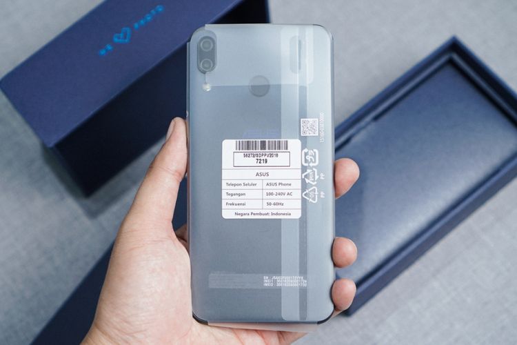 Di balik karton booklet, ZenFone 5 menyambut dalam keadaan masih terbalut plastik pelindung. Terlihat unit kamera ganda di bagian pungung ponsel ini.
