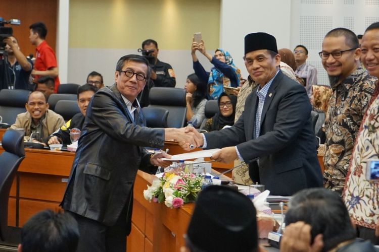 Menteri Hukum dan HAM Yasonna Laoly bersalaman dengan Ketua Pansus RUU Antiterorisme Muhammad Syafii saat rapat kerja di Gedung Nusantara II, Kompleks Parlemen, Senayan, Jakarta, Kamis (24/5/2018). Pemerintah dan DPR sepakat untuk segera mengesahkan draf revisi Undang-Undang Nomor 15 Tahun 2003 tentang Pemberantasan Tindak Pidana Terorisme (RUU Antiterorisme) menjadi undang-undang.  Dalam rapat kerja pembahasan RUU Antiterorisme, seluruh fraksi di DPR bersama pemerintah telah menetapkan definisi terorisme yang selama ini menjadi perdebatan dalam pembahasan. 