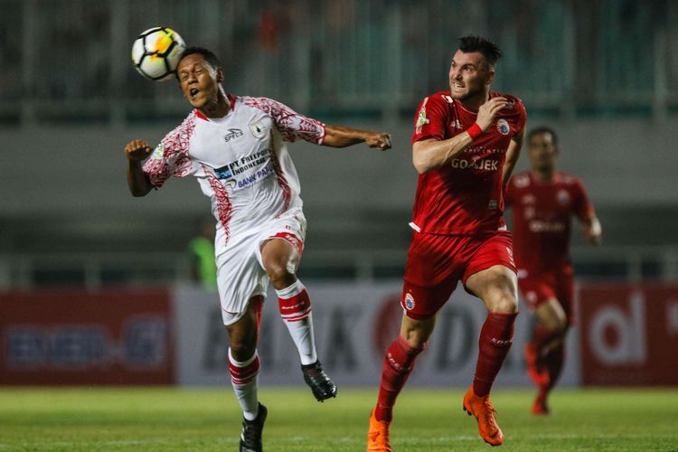 Pemain Persija Jakarta Marco Simic berebut bola dengan pemain Persipura Jayapura saat Liga 1 2018 di Stadion Pakansari, Bogor, Jumat (25/5/2018). Persija menang dengan skor 2-0.