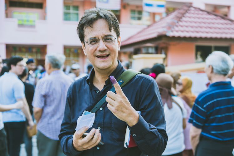 Penulis Karim Raslan menunjukkan tinta yang menempel di jari telunjuknya setelah menggunakan hak suaranya pada 9 Mei 2018.