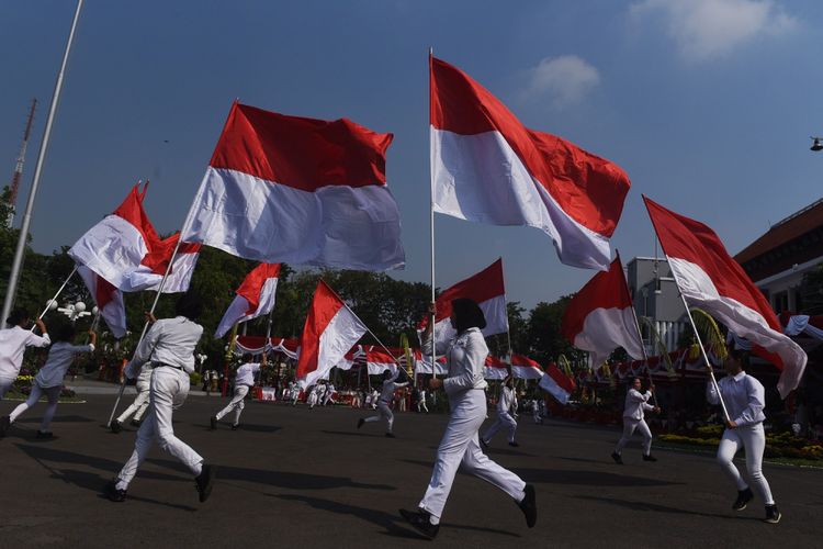 Sejumlah pelajar membawa bendera merah putih saat upacara hari jadi Kota Surabaya ke-725 di Taman Surya, Surabaya, Jawa Timur, Kamis (31/5). Dalam upacara tersebut juga ditampilkan sejumlah hiburan dan Tari Remo kolosal dengan jumlah penari sebanyak 725 penari gabungan dari SD se-Surabaya.