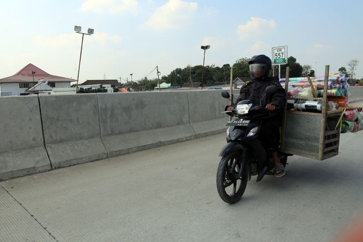 Warga yang berkendara dengan motor di seksi ruas tol Kertosuro-Sragen di rute Solo-Ngawi, Senin (4/6/2018). Ruas ini dijadwalkan akan segera dioperasikan sebagai tol fungsional pada musim mudik lebaran 2018.