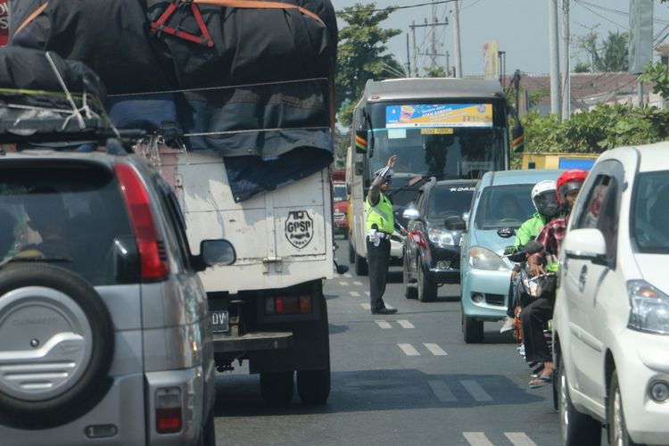 Petugas Satlantas Polres Kebumen mengatur arus kendaraan di jalur selatan Jawa, Senin (11/6/2018).