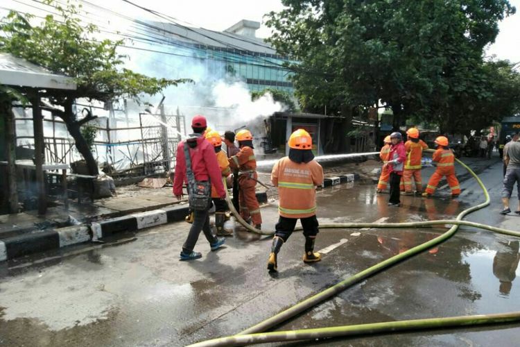 Petugas tengah memadamkan api yang membakar sebuah rumah makan di Jalan Soekarno Hatta, RT04/05 Kelurahan Mekarmulya, Kecamatan Panyileukan, Kota Bandung.  Selain bangunan yang hangus, dua orang mengalami luka bakar. 