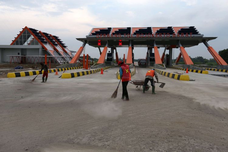 Pekerja membersihkan ruas jalan tol Mojokerto Barat - Mojokerto Utara, Jawa Timur, Senin (27/06/2016). Ruas jalan tol ini rencananya akan dibuka sementara untuk jalur mudik lebaran. KOMPAS IMAGES/KRISTIANTO PURNOMO