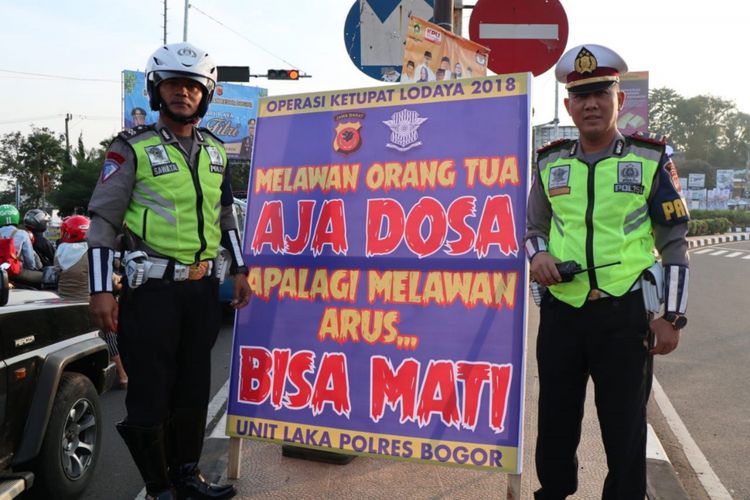 Polisi memasang spanduk imbauan dengan kata-kata nyeleneh yang ditujukan kepada pengendara jalan yang melintas di jalur Puncak, Bogor, Jawa Barat.