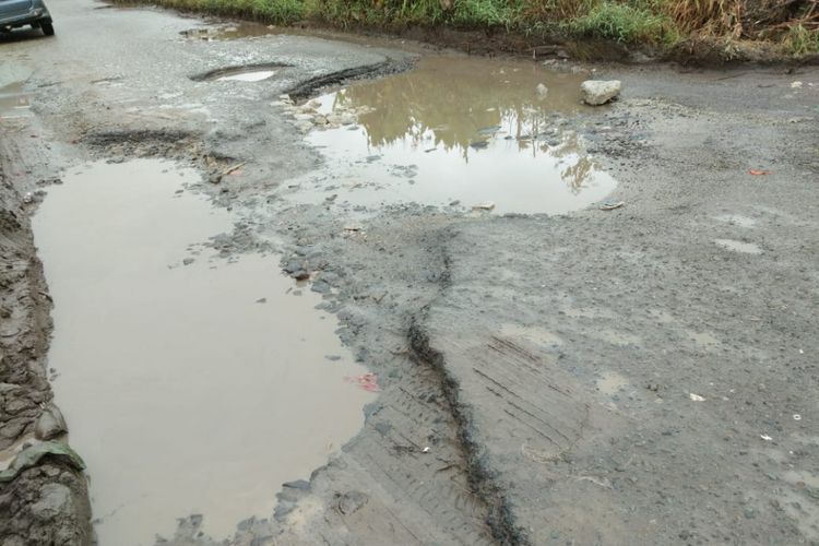 Ruas jalan di Sidamanik, Kabupaten Simalungun menuju kawasan Danau Toba betlubang dan digenangi air seperti kubangan, Kamis (21/6/2018).