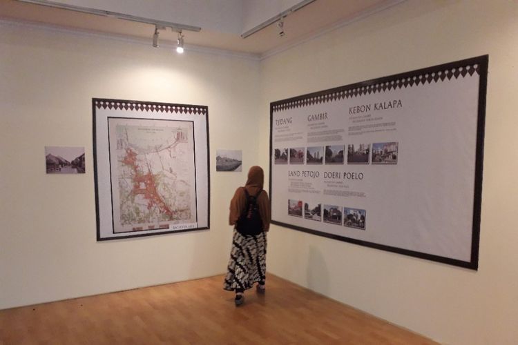 Seorang pengunjung tengah memerhatikan peta Jakarta yang dipamerkan dalan pameran Wall of Frame Sejarah Betawi yang digelar di Pasar Seni Ancol, Sabtu (23/6/2018). 