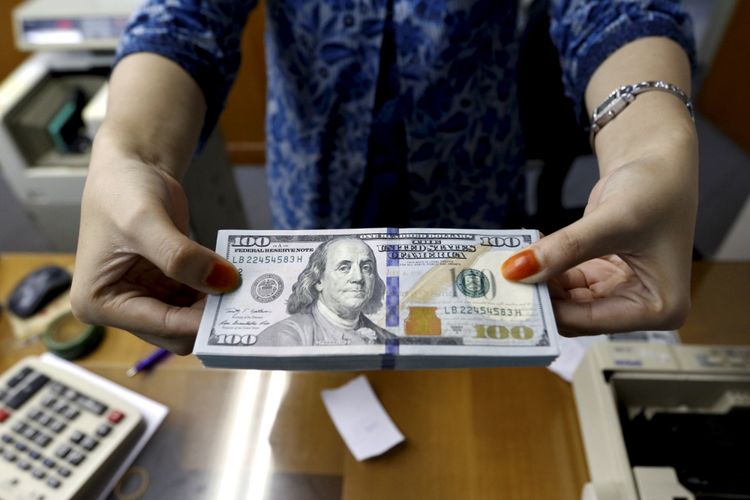 Petugas menunjukan pecahan dollar Amerika di salah satu gerai penukaran mata uang di Kwitang, Jakarta, Jumat (29/6/2018). Nilai tukar rupiah terhadap dollar AS pada perdagangan Jumat (29/6/2018) siang berada pada level Rp 14.360.