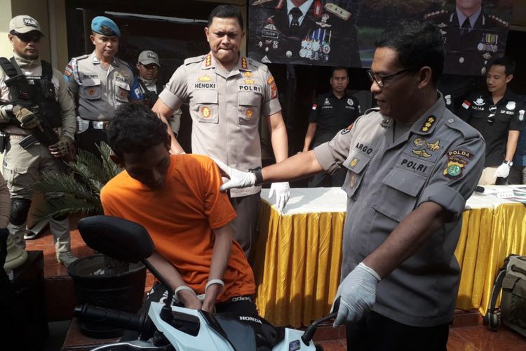 A, pelaku penjambretan terhadap Dirjen Bina Konstrukti Kemenpupera memeragakan aksinya di Mapolres Metro Jakarta Barat, Jumat (29/6/2018).