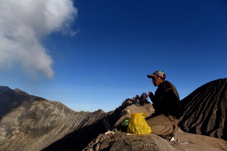 Seorang masyarakat Suku Tengger berdoa di bibir kawah Gunung Bromo usai melarung sesajinya di kawah tersebut pada Upacara Yadnya Kasada, Probolinggo, Jawa Timur, Sabtu (30/6/2018). Upacara Kasada merupakan upacara adat masyarakat Suku Tengger sebagai bentuk ucapan syukur kepada Sang Hyang Widi sekaligus meminta berkah dan menjauhkan dari malapetaka.