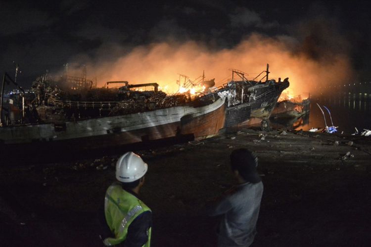 Sejumlah warga dan nelayan berusaha memadamkan api yang masih membakar sejumlah kapal ikan di Pelabuhan Benoa, Denpasar, Bali, Selasa (10/7). Hingga Selasa (10/7) dini hari, api masih membakar sejumlah titik terbakarnya 40 unit kapal nelayan yang terjadi sejak Senin (9/7) pukul 02.00 Wita yang diperkirakan menimbulkan kerugian mencapai Rp120 milliar tersebut.