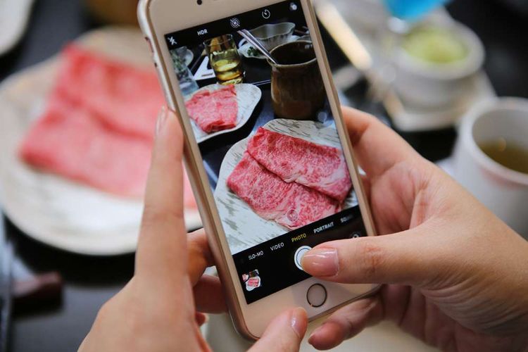 Salah seorang wartawan yang diundang untuk mencicipi hidangan omi hime beef di Restoran Kahyangan, Jakarta, mengabadikan tekstur daging itu dengan kamera ponsel, Selasa (10/7/2018). Omi hime beef adalah salah satu wagyu tertua asal Jepang, dengan keistimewaan dagingnya yang lembut dan manis ketika disantap, bahkan dalam kondisi setengah matang atau mentah sekalipun.