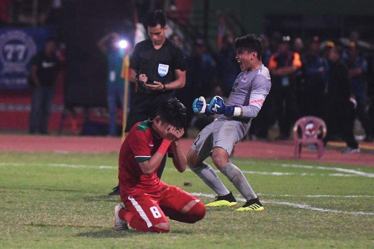 Pesepak bola Indonesia U-19 Witan Sulaeman (kiri) menutup wajahnya ketika gagal memasukan bola ke gawang  Timnas Malaysia U-19 saat adu penalti dalam laga semifinal Piala AFF U-19 di Gelora Delta Sidoarjo, Sidoarjo, Jawa Timur, Kamis (12/7/2018). Indonesia kalah adu penalti dari Malaysia dengan skor 3-4.